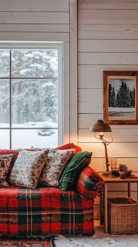 Cozy rustic living room with a plaid couch, warm lighting, and snowy winter view outside the window. Scottish Living Room, Scottish Interior Design, Scottish Cottage Interior, Plaid Couch, Scottish Home Decor, Cozy Farmhouse Christmas, Scottish Interiors, Earthy Living Room, Farmhouse Christmas Decor Ideas