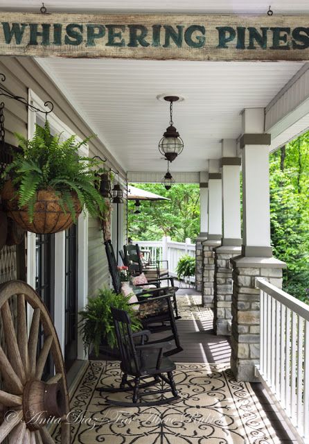 A consistent color scheme with a heavy dose of patterns mixed in helps to give the entire porch a more cohesive feel. White accents, including the paneled ceiling and fencing, help brighten the space up. Country Front Porches, Farmhouse Porch Decor, Southern Porches, Whispering Pines, Building A Porch, Rustic Porch, Vintage Farmhouse Style, Country Porch, Farmhouse Front Porches