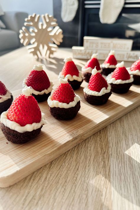 3 Ingredient Easy Strawberry Brownie Santa Hats | Lynn Mumbing Mejia Strawberry Santa Hats Recipe, Brownie Bite Santa Hats, Brownie Strawberry Santa Hats, Santa Hat Treats, Santa Brownie Bites, Santa Strawberry Hats, Easy Dessert Buffet Ideas, Things To Bake For Christmas Party, Christmas Desserts With Strawberries