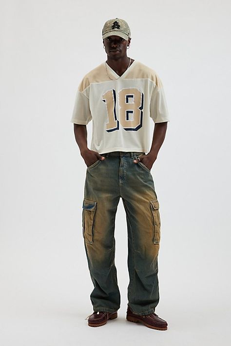 Mesh football jersey by Urban Outfitters. Semi sheer short sleeve t-shirt with a number graphic at the front. Boxy fit tee in a cropped length. Features UO football jersey Mesh football jersey tee Two-tone V-neck Number graphic Short sleeve Cropped length Content + Care 100% Polyester Machine wash Imported Size + Fit Model in Neutral is 6’2.5" and wearing size Medium Measurements taken from size Medium Chest: 46" Length: 23.5" | Urban Outfitters UO Mesh Football Jersey Tee in Neutral, Men's at U 90s Outfits For Men, Mesh Jersey Outfit Men, Football Jersey Streetwear, 80s Crop Top Men, Mens Cropped Shirt, Men’s Summer Streetwear Style, Cropped Shirt Outfit Men, Cropped Jersey Outfit, Festival Looks Men