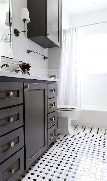 Black and white vintage floor tiles complement a black washstand adorned with brass knobs and a white and gray marble countertop. Katie Davis Design, Black And White Bathroom Floor, Katie Davis, Black Tile Bathrooms, Black And White Tiles Bathroom, Marble Bathroom Floor, Black White Bathrooms, White Bathroom Tiles, White Tile Floor