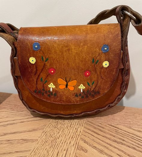 #Coachella #70spurse #tooledfloralpurse #bohohippiebag #Mexicanleatherbag #Mexicanpurse #hippievintagepurse #boholeather purse #tooledleatherpurse #hippieleatherpurse #Coachellabag #woodstock #vintagehippie #leathermushroom Leather Purse Pattern, Handmade Leather Purse, Hippie Purse, 70’s Style, Purse Pattern, Flowers Butterfly, Tooled Leather Purse, 70s Style, Painted Flowers