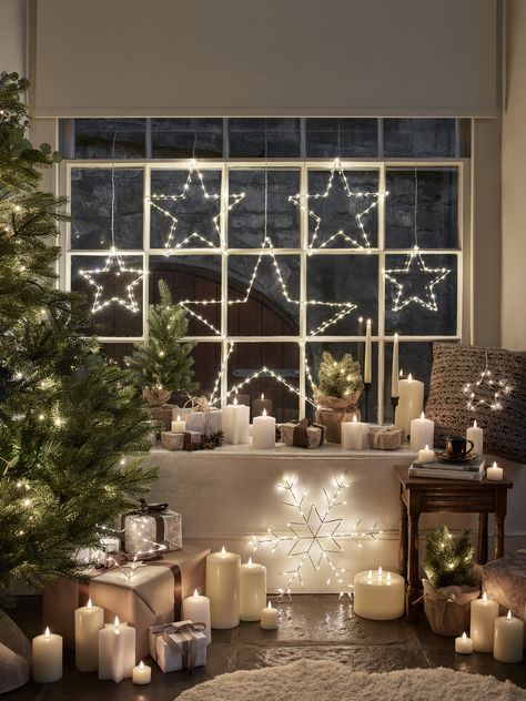 A Christmas window with star lights, LED Christmas candles and mini Christmas trees. Lounge Christmas Decor, Christmas Kitchens, Christmas Window Lights, Christmas Window Stickers, Light Up Pumpkins, Winter Things, Christmas Window Display, Elegant Christmas Decor, Christmas Window Decorations