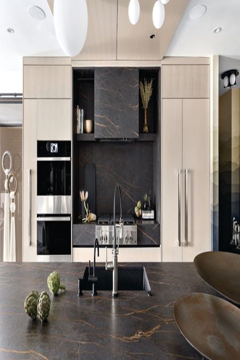 When Aleem Kassam, principal of Kalu Interiors, designed the sleek kitchen in his own downtown Vancouver condo, he fell head-over-heels with a bronze-veined, dark brown stone (specifically, Cosentino’s Dekton Laurent). He was all in. “When you have a material that works well in a space, why not try to take it to the next level?” says Kassam. Dekton Laurent, Dark Brown Kitchen, Vancouver Condo, Dark Counters, Miller House, 2022 Kitchen, Miller Homes, Sleek Kitchen, Brown Kitchens