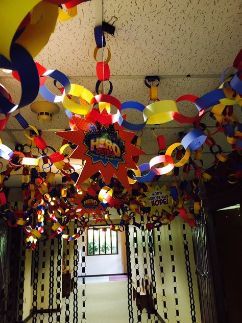 Ways to be a hero decorator! Use binder clips to attach paper chains to the ceiling. The long chain at the end were done using only black paper and it looked cool! Also, add the Hero Code Mobiles to carry out the theme. cokesburyvbs.com Superhero Ceiling Decor, Superhero Vbs Decorations, Super Hero Vbs, Vbs Superhero Theme, Hero Central Vbs, Superhero Vbs, Hero Crafts, Vbs Decorations, Bible Heroes