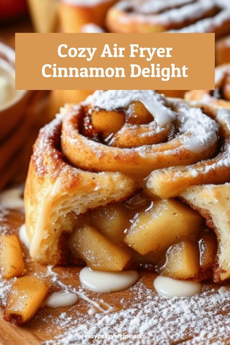 Close-up of a freshly baked air fryer apple cinnamon roll drizzled with icing and dusted with powdered sugar. Canned Cinnamon Rolls In Air Fryer, Baking Vocabulary, Air Fryer Apple Cinnamon, School Cookies Recipe, Air Fryer Cinnamon Rolls, Food Air Fryer, Apple Rolls, Baked Oreo Cheesecake Recipe, Oreo Cheesecake Recipes