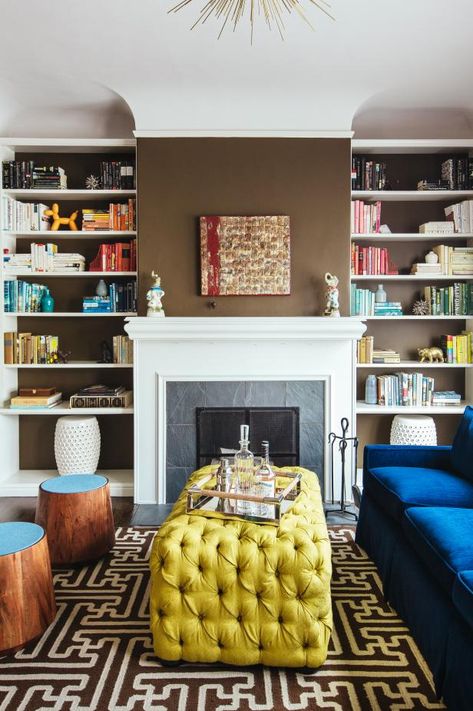 To create a sitting room that's fresh and full of visual interest, designer Noz Nozawa used brown walls as a backdrop for saturated blue and gold furniture. Books organized by color draw the eye from floor to ceiling. Fireplace Bookshelves, Floating Shelf Decor, Floating Bookshelves, White Fireplace, Bookshelf Design, Chic Spaces, Eclectic Living Room, Brown Walls, Living Room White