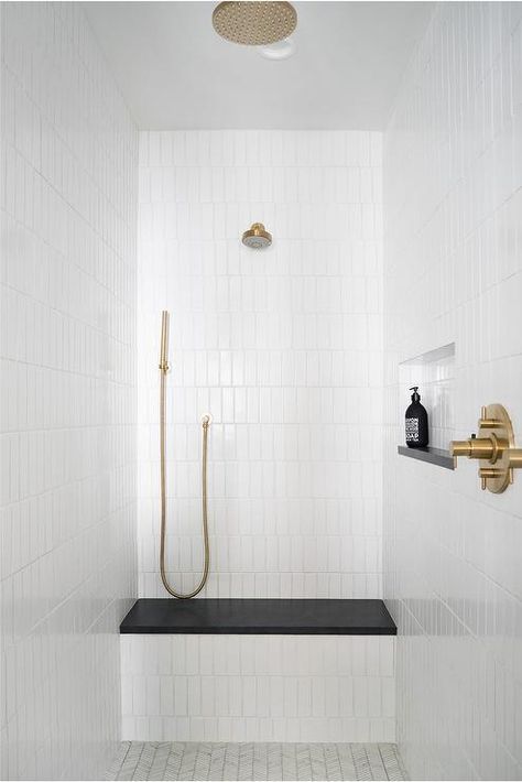 White vertical stacked shower wall tiles brings an appealing look to a walk in shower showcasing a black quartz slab shower bench a brushed gold shower kit. Mindy Gayer Design, White Tile Shower, Subway Tile Showers, Shower Wall Tile, Gold Shower, Shower Seat, Shower Bench, Bainbridge Island, White Shower