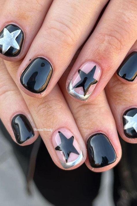 These short, rounded nails present a chic and playful contrast. A glossy black base gives a classic, sophisticated look, while pink nails with bold black stars add a pop of whimsy. Metallic silver embellishments outline some of the designs, providing a striking frame that ties the look together seamlessly. It's a modern twist on a starry night theme, full of style and fun! ✨  // Photo Credit: Instagram @blendedbeauty.mb Star Short Nail Designs, Metallic And Black Nails, Silver Nails With Black Stars, Pop Star Nails, Cute Manicures For Short Nails, Nail Inspo Black And Silver, Black Chrome Nails Short, Black Nails With Chrome Design, Short Nail Star Designs