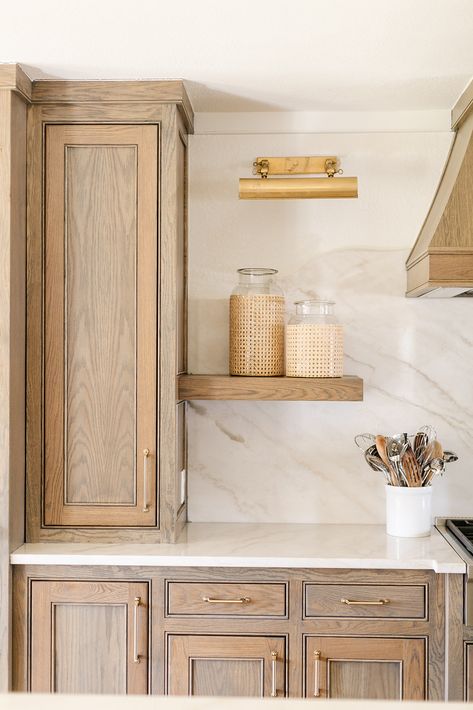 We included a curved stone backsplash in this elegant kitchen remodel. We love how the chamonix quartzite provides beauty to both the countertop and backsplash, and complements the warm, stain-grade cabinets. We finished off the space with a gold library light and textured accessories. Curved Kitchen Countertops, Kitchen Limestone Backsplash, Stone Backsplash Wood Cabinets, Limewash Travertine Backsplash, Travertine Backsplash Kitchen Farmhouse, Stone Kitchen Backsplash, Gold Library, 2024 Design Trends, Prepare Breakfast