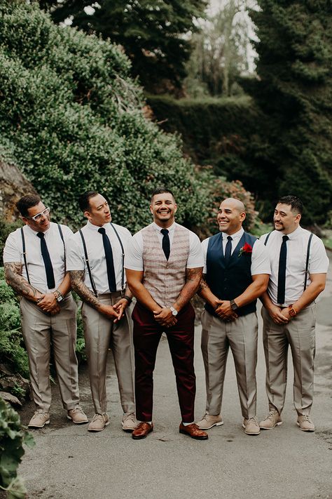 Groom in a burgundy suit. Groomsmen in suspenders and tie. Short sleeve button up.  Navy blue accents with champagne colored pants. Non-traditional groomsmen , wedding party.  Tan shoes for groomsmen. Brown for the groom Mismatched Groomsmen, Groomsman Attire, Navy Groomsmen, Groom Suspenders, Groomsmen Suspenders, Garden Party Outfit, Party Outfit Men, Mens Wedding Attire, Groom And Groomsmen Attire