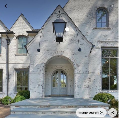 Stone House With Black Shutters, Brick Archway Exterior, European Country Exterior, Stone And Painted Brick House Exterior, German Shmere Brick House Exterior, German Shmere Brick House, White Brick And Stone Exterior, Stone And Brick House Exterior, Black Gutters