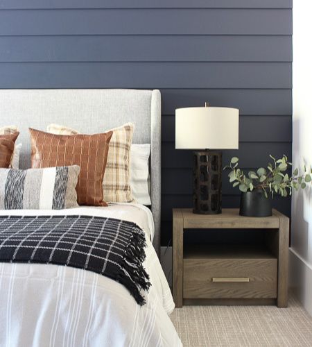 A tailored bedroom design with hale navy blue shiplap wall, cozy plaids, wool and stripes layer the bed and chic leather for a cozy contemporary vibe. Navy Blue Shiplap Wall, Blue Shiplap Wall, Blue Shiplap, Tan Bedroom, House Of Silver Lining, The House Of Silver Lining, Cozy Contemporary, Navy Bedrooms, Boy Bedrooms