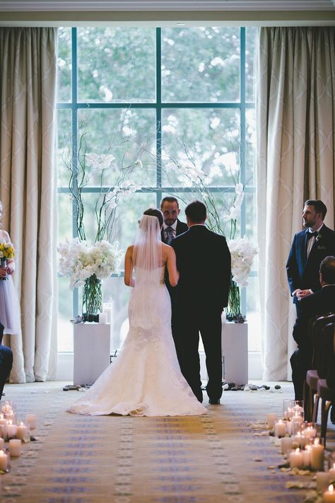 River Crest Country Club ceremony in front of large windows with a white flower and branch archway Wedding Ceremony In Front Of Windows, Crest Hollow Country Club Wedding, Hunt Valley Country Club Wedding, Silverleaf Country Club Wedding, Ceremony Archway, Congressional Country Club Wedding, Country Club Reception, Gorgeous Interiors, Evening Wedding