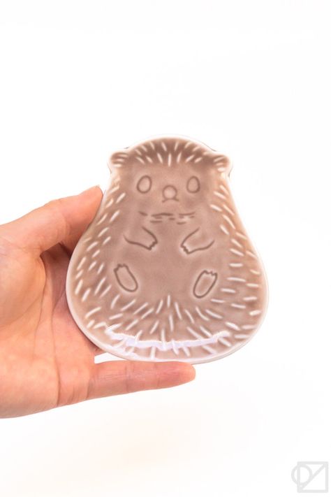 These palm-sized dishes are adorable renditions of woodland animals and full of whimsy. They're made as sauce dishes, but you can use them how you like. Fox (yellow), Bear (teal), Hedgehog (rose), and Owl (green) designs, sold separately Measures approximately 4.5" x 4" x 0.5" Ceramic Dishwasher safe Made in Japan Hedgehog Ceramic Pottery, Woodland Ceramics, Animal Ceramics, Company Calendars, Cerámica Ideas, Woodland Animal, Pottery Ideas, Ceramic Dishes, Green Design