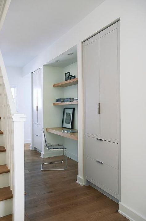 Foyer hall alcove is filled with a wood floating desk under stacked wood floating shelves paired with an Ikea Ghost Chair, Ikea Tobias Chair, flanked by alcoves filled with gray cabinets. Grey And White Hallway Ideas, Grey And White Hallway, White Hallway Ideas, Hallway Cupboards, Hallway Ideas Diy, White Hallway, Blue Grey Walls, Modern Kitchen Lighting, Modern Entrance