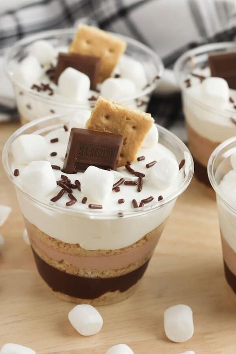 Looking for fun and easy desserts that kids can make? These s'mores pudding parfait cups are pretty and easy to make in just a few minutes! Older kids could even make these instant chocolate pudding desserts by themselves! Learn how to make these cute pudding cups for simple sweet treats to cool off this summer! Pudding In A Cup Desserts, S’mores Pudding Parfaits, Family Party Desserts, Individual Pudding Cups, Homemade Pudding Cups, Birthday Pudding Cups, Easy Diy Dessert Shooters, School Friendly Desserts, S’mores Parfait Cups