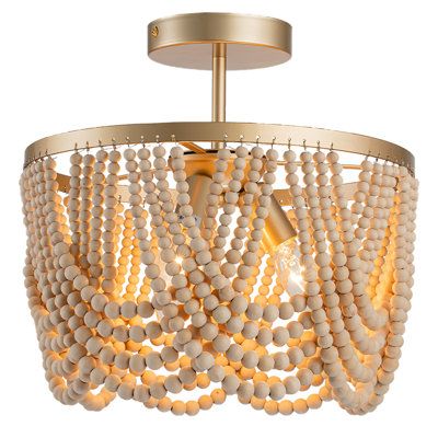 Drawing inspiration from the timeless Bohemian style, our Bohemian chandelier features oak wood beads and high-quality gold metal brackets. The layered wooden beads create captivating plays of light and shadow on the ceiling, infusing your space with a relaxed and romantic Bohemian ambiance. Finish: Gold | Bungalow Rose Pragati 3-Light Boho Wood Beaded Semi Flush Mount Wood / Metal in Yellow | 12.6 H x 12.6 W x 12.6 D in | Wayfair Dimmable Light Switch, Beaded Light Fixture, Wood Beaded Chandelier, Boho Light Fixture, Bohemian Chandelier, Boho Lighting, Boho Chandelier, Wood Bead Chandelier, Bedroom Light Fixtures