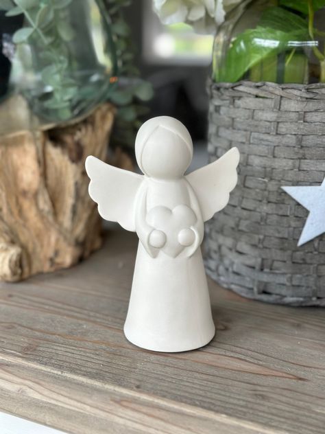 LED White ceramic glazed Angel holding a Heart. A delightful christmas ornament with LED lights, featuring a sweet angel, holding a heart. Complete with a matte white finish and a festive feel.  Two sizes available. Small - 10cm x 11.5cm Medium  - 12cm x 16cm (Batteries Included) Sending as a gift? Select Gift at checkout and add your personal message. Gifts are sent without priced invoices. Angel Ceramic Handmade, Ceramic Angel Ornament, Angel Clay Sculpture, Pottery Angels Christmas, Ceramic Christmas Decor, Pottery Angels Hand Built, White Clay Ideas, Christmas Ceramic Ornaments, Clay Angels Handmade