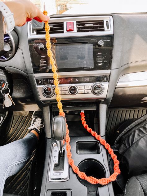 A bright-colored macrame phone charger plugged into the USB port inside a car. Color of phone charger is called sunburst which is an ombré style of red fading to yellow Boho Car Ideas, Diy For Car Decor, Cute Car Inside Decor, Diy Car Decor Interior, Artsy Car Interior, Car Decorations Crochet, Cozy Car Interior Ideas, Boho Car Aesthetic, Car Interior Decor Diy