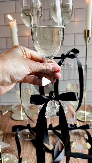 •Stephanie Bryant• on Instagram: "the bow trend?! I’m obsessed! 😍 the perfect finishing touch to a New Year’s Eve (or anytime)  party 🎀🥂🥂 here is how I make mine   Tie a knot onto your glass then form two bunny ears - cross the right one over the left then loop behind and thread it back through the center - pull both ears to tighten then pull on the ends until you’ve reached your desired size and shape bow!   Make sure to save this reel and  follow @the_blonde_kitchen for more entertaining tips! 🖤🤍  #theblondekitchen #tbksocialclub #supperclub #newyearseve #bowtrend #bow #partyideas #entertainingathome #tablesetting #tablescapes #entertainingideas #newyears #champagne #fayettevillear #holidayinspo #decorideas #partyinspo" New Year Engagement Party, New Years Eve Bachelorette Party, Tying The Knot Engagement Party, Bow Champagne Glasses, Bows On Glasses, Champagne Glasses With Bows, Bows On Champagne Glasses, New Year’s Eve Engagement Party, Black Tie Engagement Party