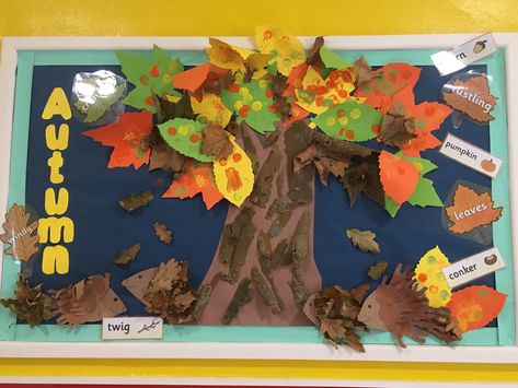 Autumn Display board made by using children’s artwork and natural resources. Leaves were made by exploring shapes while mark making and real leaves, the tree has real bark attached to it from our sensory bins and the hedgehogs are made from handprints and some from sticking down real leaves. The board also includes seasonal and action words to help promote  early litreacy. Nursery Autumn Display, Autumn Displays Eyfs, Autumn Wall Display Preschool, Autumn Tree Display Eyfs, Autumn Display Board Eyfs, Autumn Classroom Display, Autumn Display Boards Nursery, Autumn Display Eyfs, Autumn Display Boards