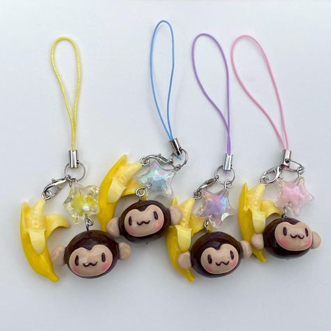 A handmade accessory featuring a polymer clay blushing monkey charm! This charm also features a plastic banana and star bead. The monkeys are finished with a glossy UV resin glaze, making them shiny and sturdy. Push the charms through the loop to secure it to a phone case, bag handle, set of keys, DS, camera, switch, and much more! Please be aware that each charm is handmade, so each has slight variations from one another. Please understand that these charms may also have imperfections or visible dust in the clay. Handmade Items can be fragile so please treat with care! Thank you for checking out my shop! Feel free to reach out with any questions or requests. My work can also be found on instagram: @shopcatsintheclouds PLEASE check your shipping address before confirming your purchase. If Clay Trinkets Easy, Aesthetic Trinkets, Clay Phone Charm, Clay Monkey, Monkey Bag, Clear Phone Case Design, Monkey Banana, Monkey Keychain, Decoden Diy