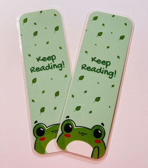 This happy little frog is reminding you to keep reading! The laminated bookmark measures 6" x 2" inches. Bookmark About Reading, Bookmark Ideas Aesthetic Qoutes, Simple Bookmark Design, Creative Bookmarks Art, Homemade Bookmarks Diy, Bookmarks Handmade Creative, Frog Bookmark, Origami Bookmark Corner, Bookmarks For Kids