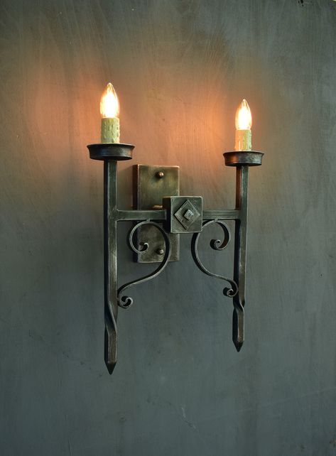 Gothic 2-light wall sconce,Medieval style torch shaped wall light,Wrought iron wallchiere Inspired by a Gothic castle, this fixture is made from wrought iron with a matte black iron finish with the possibility of patination with silver or copper patina. Wrought Iron Wall Lights, Cellar Basement, Blacksmith Workshop, Tuscan Interior, Welding Ideas, Torch Lamp, Gothic Castle, Blacksmith Projects, The Torch