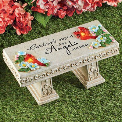 A lovely way to celebrate the memory of a loved one, this bench is beautifully detailed and accented with flowers and cardinals that automatically shine with solar-powered light at night. The bench has a touching inscription that reads: Cardinals appear when Angels are near. This bench includes a 1 AA rechargeable battery. | Arlmont & Co. Twilley Solar Cardinal Bench Memorial Plaque / Stone Resin / Plastic in Gray | 5.75 H x 12.5 W x 5.75 D in | Wayfair Memorial Garden Stones, Memory Of A Loved One, Memorial Benches, Stone Bench, Solar Powered Lights, Memorial Plaque, Memorial Stones, Collections Etc, Garden Accents