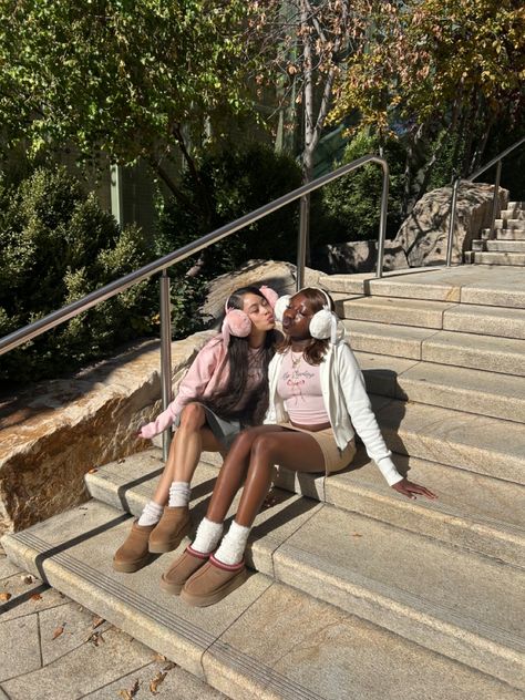 Two friends in cozy fall outfits, wearing earmuffs, sweaters, and plush boots, sit on stone steps outdoors, sharing a playful moment on a sunny autumn day surrounded by trees and greenery. Cozy Autumn Outfits, Fall Fashion Ideas, Cute Fall Fashion, Best Aesthetic, Aesthetic Cozy, Cozy Fall Outfits, Cozy Outdoor, Outdoor Photoshoot, Cozy Autumn