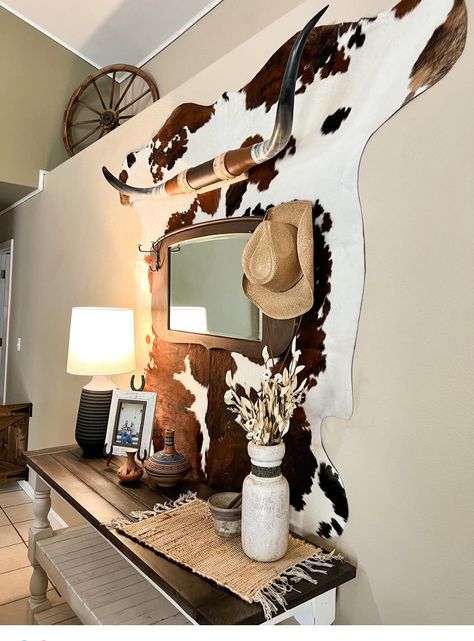 Cowhide Rug On Wall With Pictures, Boho Western Salon Decor, Cowhide Wall Decor Living Room, How To Hang A Cowhide On The Wall, Dollar Tree Western Decor, Vintage Western Room Decor, Cow Hide Rug On Wall, Western Shelf Decor Ideas, Cow Rug On Wall