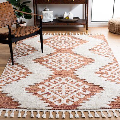 This area rug grounds your space in a bright pattern and fun texture. It's power-loomed from polypropylene that's made to be stain- and mildew-resistant. The rustic design features geometric patterns inspired by Southwestern textiles, with an orange base and white, fluffy zig-zag lines. We love that the high-low pile height and playful tassels add dimension to your floors while providing extra cushion and coziness - ideal for your bedroom or den. Pick up a rug pad to help keep it in place underf Living Room Orange Accents, Southwestern Area Rugs, Bedroom Remodel, Ivory Area Rug, Library Design, Boho Living, Boho Designs, Ivory Rug, Boho Bedroom