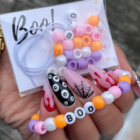 Looking for a fun interactive way to celebrate Halloween this year? Look no further! Personalized Individually Wrapped DIY Halloween Bracelet Kit is a great classroom or Girl Scout troop gift! Perfect for a Pink - A - Boo party! Each kit comes with: 12 inches of white elastic for bracelet  24 beads (6 white - 6 pink - 6 purple - 6 orange) BOO letter beads (1 B - 2 O's) Beads & elastic is placed in a clear tube !  WARNING: CHOKING HAZARD - Small parts. Not suitable for children under 3 years. Kids Halloween Class Gifts, Bracelet Kit Party Favor, Halloween Crafts For Party, School Halloween Gifts, Pink Orange Halloween Party, Small Halloween Party Ideas For Kids, Things To Sell For Halloween, Pink Halloween Bracelet, Halloween Things To Make And Sell