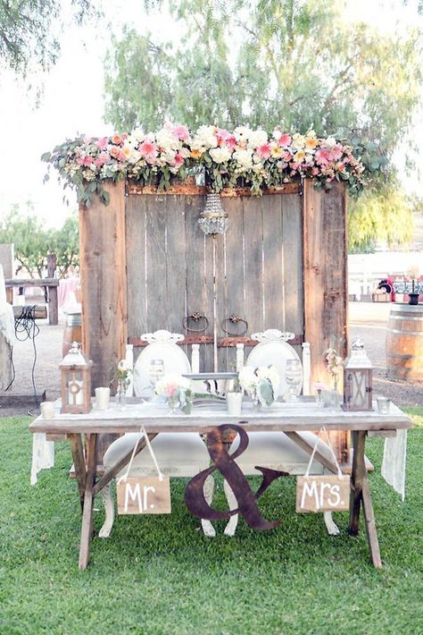 old door wedding decoration wedding table of the bride and groom on the background of the door decorated with a chandelier and flowers leah marie photography Forest Wedding Favors, Sweetheart Table Backdrop, Bride And Groom Table, Door Backdrops, Rustic Wedding Table Decor, Rustic Wedding Reception, Rustic Wedding Table, Table Set Up, Wedding Table Decorations