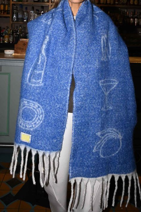 Made with playful sketches of chic cuisine and thoughtfully made from recycled materials, our Girl Dinner Scarf is an oversized, chunky blanket scarf made for getting stopped on the street.  Cerulean blue coloring Sketches of a martini glass, champagne, a lemon, a plate, and two fish Loose twisted fringe ends 97% recyc Winter Outfits Aesthetic, Oversized Blanket, Girl Dinner, Chunky Scarves, Chunky Blanket, Cozy Loungewear, Colorful Scarf, Oversized Scarf, December 2023