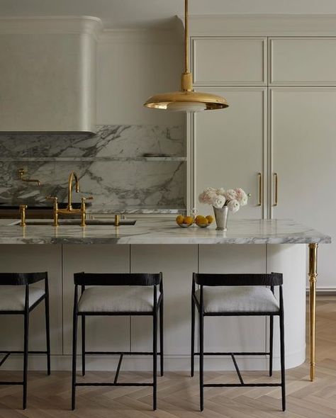 Meg Cassidy on Instagram: "For this Toronto kitchen, our intention was to draw inference from classical European influences. The herringbone floor and Venetian plaster hood brought texture to the space paired with the old world feel of unlacquered brass fixtures and those island legs, well they are just magical. ✨  Adjacent to the kitchen through an arched opening is a pantry clad in brass cabinets and a marble wall of shelves for all the curiosities.   Design | Studio Meg Cassidy Photography | @niamhbarryphoto" Plaster Cabinets, White Kitchen With Marble Countertops, Brass Cabinets, White Kitchen With Marble, Neo Classic Kitchen, Kitchen With Marble Countertops, Plaster Hood, Arched Opening, Kitchen With Marble