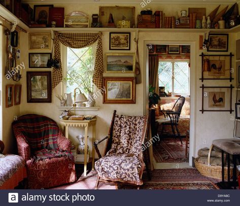 Tartan throw on red armchair in cluttered living room with antique campaign chair and high shelf with collection of objects Stock Photo Doorway Shelves, Cottage Ceiling, English Cottage Interiors, High Shelf, Space House, Ceiling Shelves, Door Shelf, English Cottage Decor, Setting Inspiration