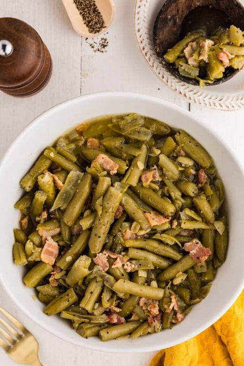 These Country Style Green Beans take simple canned green beans to the next level, adding the savory flavors of bacon and onion for a dish that's packed with Southern comfort. A Cracker Barrel copycat, this simple recipe is a true classic with a delicious, home-cooked feel. | www.persnicketyplates.com Country Style Green Beans, Country Green Beans, Southern Green Bean Recipes, Canned Green Bean Recipes, Cracker Barrel Copycat, Ham And Green Beans, Southern Style Green Beans, Canned Green Beans, Southern Green Beans