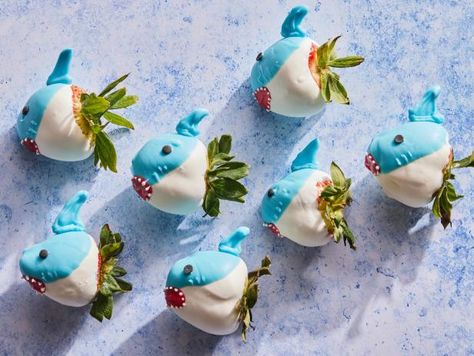 It’s time to get ready for the most 'jawsome' week of the year: Shark Week! If you’re anything like us you’ve already started stocking up on viewing party essentials—which makes this the perfect time to start planning your menu. Whether you’re leaning towards a showstopping shark cake, an entire school of shark-themed cupcakes or savory snacks that everyone will want to sink their teeth into, you’ll find all the recipes you need right here—starting with these fun chocolate-dipped strawberries. They come together quickly and are easy to make. For the most “sharky” look, we suggest choosing large, stem-on strawberries that are just a bit flat at the tip (versus very pointy). To prevent condensation, refrigerate the little sharks for no more than 2 hours before serving—or chomping! Shark Strawberries, Shark Treats, Pumpkin Cheese Ball Recipe, Shark Week Recipes, Ice Cream Sundae Recipe, Shark Week Party, Sundae Recipes, 7 Fishes, Shark Cake