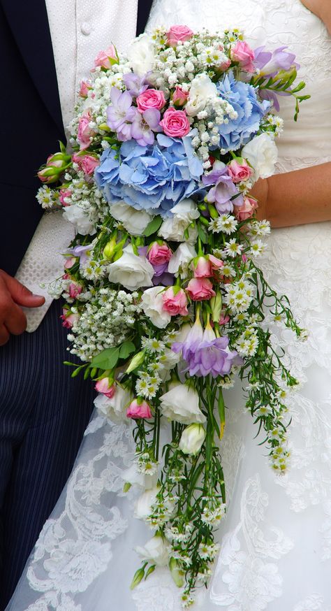 A cascading wedding bouquet in pastel colours at Blake Hall Colorful Cascade Wedding Bouquet, Cascading Pastel Bridal Bouquet, Flower Cascade, Pastel Bridal Bouquet, Lavender Bridal Bouquet, Elegant Bridal Bouquets, Cascading Bridal Bouquets, Cascading Wedding Bouquets, Purple Wedding Bouquets