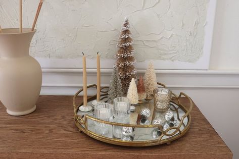 A mirrored tray makes a chic centerpiece when layered with reflective elements like mercury glass and glittered trees that really up the sparkle factor. It adds such a cozy feeling to your space— when you light the candles at night, the flames flicker and glow in the reflection of the mirror. Christmas Mirror Tray, Mirror Tray Decor Ideas, Mirrored Tray Centerpiece, Candles At Night, Mirror Tray Decor, Holiday Centerpieces Diy, Centerpiece Tutorial, Mirror Centerpiece, Tray Centerpiece