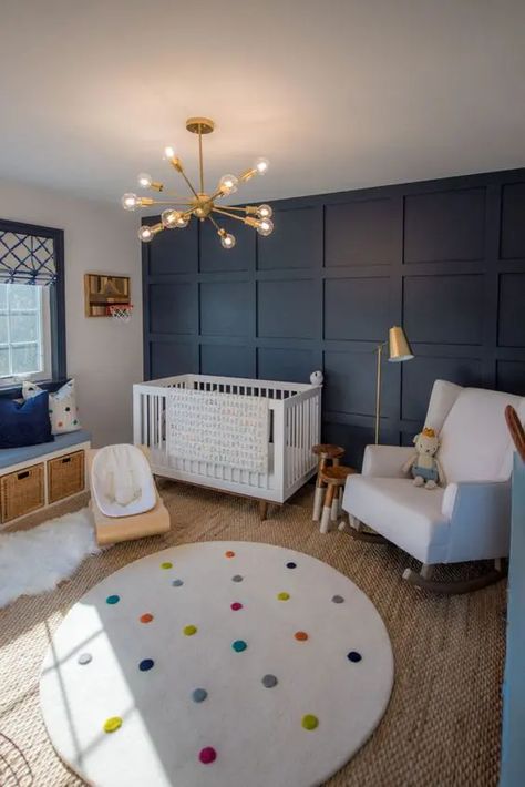 a cheerful nursery with a navy paneled wall, white furniture, a bench with storage, layered rugs and a cool modern chandelier Teenage Boy Room, Baby Nursery Inspiration, Baby Boy Room Decor, Nursery Room Boy, Nursery Room Design, Baby Boy Room Nursery, Nursery Room Inspiration, Blue Nursery, One Room Challenge