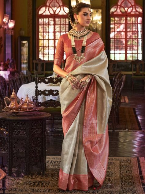 Be a stunner and make your fashion game stronger with this astonishing Cream Heavy Weaving Kanjivaram Silk Wedding Wear Saree. This elegant saree is made of high-quality kanjivaram silk material and features heavy zari weaving and tassels, adding a touch of traditional charm to your look. The cream color of the saree exudes grace and sophistication, making it the perfect choice for any special occasion. The saree comes with a stunning coral-red silk blouse that complements the cream color perfec Red Silk Blouse, Party Wear Sarees Online, Kanjivaram Sarees Silk, Kanjivaram Silk Saree, Utsav Fashion, Ethnic Outfits, Art Silk Sarees, Kanjivaram Sarees, Elegant Saree