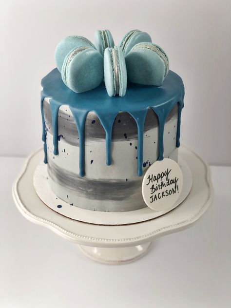 Grey and black cake with a blue drip. There are dark blue splatters. Six macarons sit on top in a circle formation. A plaque on the bottom right reads “Happy Birthday JACKSON!” Blue Macaron Cake, Cake With Macaroons, Cake With Drip, Blue Macaron, Macaron Cake, Girly Cakes, Mini Cakes Birthday, Blue Cakes, Drip Cake