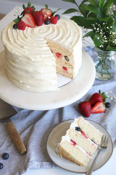 This berries & cream white chocolate cake has all of the elements for the perfect moist cake – applesauce, sour cream, and pudding mix. With a white chocolate mascarpone frosting, whipped cream topping, and berries all in between, this tender cake will keep your mouth watering for days. Great for a wedding cake, mother's day cake, birthday cake or any special occasion! White Cake Strawberries, Berry Whipped Cream Cake, White Cake With Fruit, Vanilla Cake With Berries, Whipped Cream Cake Design, White Cake Decoration, Whipped Cream Wedding Cake, Berries And Cream Cake, White Cake With Berries On Top