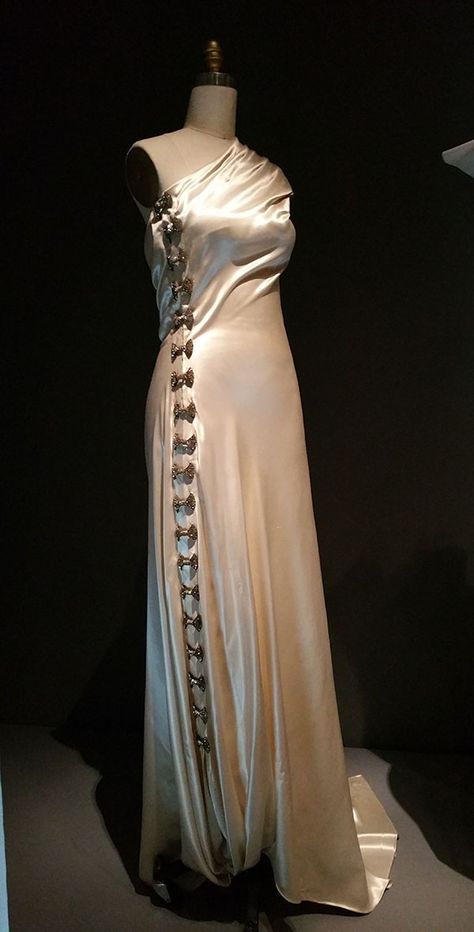 Madeleine Vionnet (French, 1876-1975); EVENING DRESS, 1936, haute couture, Machine-sewn white cellulose acetate satin, hand-finished seams and hems with hand-attached silver metal clasps and bow-shaped silver metal and clear rhinestone clips, “Everything came from my head. Bias came from my head, maybe because everyone made dresses that flowed in the same direction. But I saw that if I turned the fabric on an angle, it gained elasticity.” 1930's Dresses, Madeleine Vionnet, Couture Evening Dress, Woman Dresses, 30s Fashion, Vintage Clothes Women, Vintage Gowns, 1930s Fashion, Vintage Couture