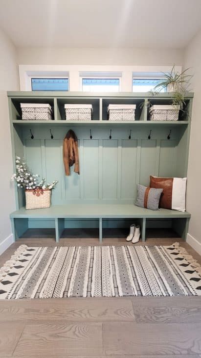 Mudroom with 4 cubbies in soft green with white, green and brown accessories Hampton Style Home, Refresh Home, Functional Mudroom, Mudroom Remodel, Mudroom Makeover, White Tile Backsplash, Mudroom Decor, Mud Rooms, Mud Room Storage