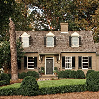 Brick Paint: Fauna by ICI Paints  Trim Paint: French White by ICI Paints  Shutters and Front Door: Mopboard Black by Pratt & Lambert Cape Cod House Exterior, Cottage Makeover, Cape Cod Cottage, Black Shutters, Brown Roof, Tan Trim, House White, Cottage Style Decor, Cape Cod House