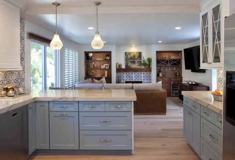 Colorful Kitchen design with blues, grays and white featuring Dura Supreme Cabinetry. Built in entertainment wall highlights the blue and white fireplace design. Kitchen With Different Color Peninsula, Kitchen On Two Opposite Walls, Square Kitchen Layout With Peninsula, Blue Wall White Cabinet Kitchen, Kitchen Peninsula Open To Family Room, Kitchen Peninsula With Stove And Oven, Extra Wide Kitchen Peninsula, Small Kitchen With Peninsula, Kitchen Tile Wall